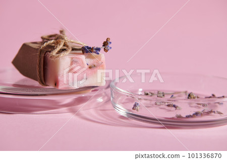 Selective focus on a bar of pink soap with natural organic ecologically-friendly ingredients, on petri dish, isolated over pink background. Hygiene and purity 101336870