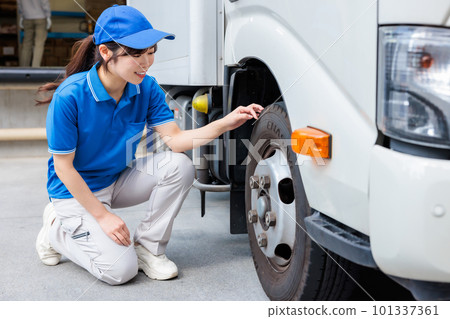 Young female driver performing pre-work inspection of truck Young female driver performing pre-work inspection of truck 101337361