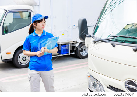 Young female driver performing pre-work inspection of truck 101337407