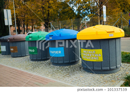 Waste sorting bins, blue, yellow, green and red. There is a sign at the top indicating the type of waste  101337539