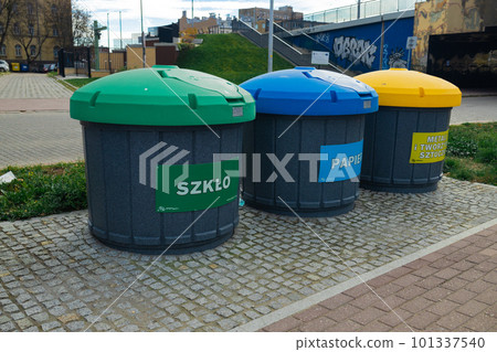 Waste sorting bins, blue, yellow, green and red. There is a sign at the top indicating the type of waste  101337540