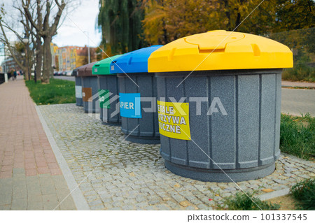 Waste sorting bins, blue, yellow, green and red. There is a sign at the top indicating the type of waste  101337545