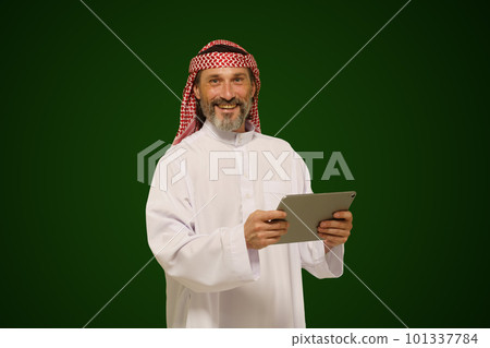 Arab Muslim man holds a digital tablet. Concept of online communication and global connection through technology. High quality photo Arab Muslim man holds a digital tablet. Concept of online communication and global connection through technology. High quality photo 101337784