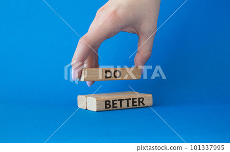 Do better symbol. Wooden blocks with words Do better. Beautiful blue background. Businessman hand. Business and Do better concept. Copy space. Do better symbol. Wooden blocks with words Do better. Beautiful blue background. Businessman hand. Business and Do better concept. Copy space. 101337995