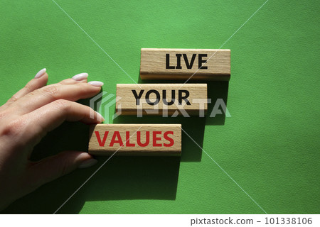 Live your values symbol. Concept words Live your values on wooden blocks. Beautiful green background. Businessman hand. Business and Live your values concept. Copy space. 101338106