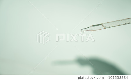 Natural medicine, cosmetic research. The concept of skin care and its analysis. Dermatology. With space to copy. Laboratory pipette with a drop of serum, oil, cosmetics. High quality photo 101338284