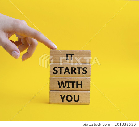 It starts with you symbol. Wooden blocks with words It starts with you. Beautiful yellow background. Businessman hand. Business and It starts with you concept. Copy space. 101338539