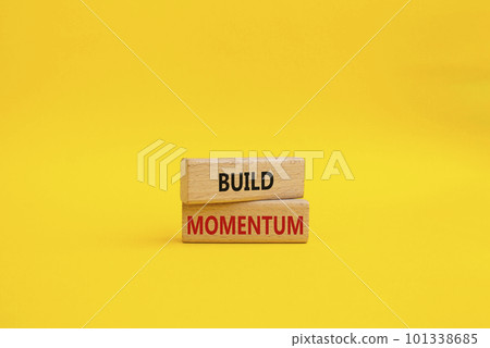 Build momentum symbol. Wooden blocks with words Build momentum. Beautiful yellow background. Business and Build momentum concept. Copy space. 101338685
