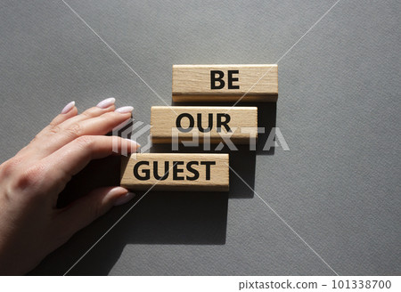 Be our guest symbol. Concept word Be our guest on wooden blocks. Beautiful grey background. Businessman hand. Business and Be our guest concept. Copy space 101338700