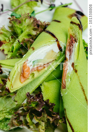 Delicious thin pancakes with salmon and sour cream. Delicious breakfast or snack, vertical image. top view. place for text Delicious thin pancakes with salmon and sour cream. Delicious breakfast or snack, vertical image. top view. place for text 101338808