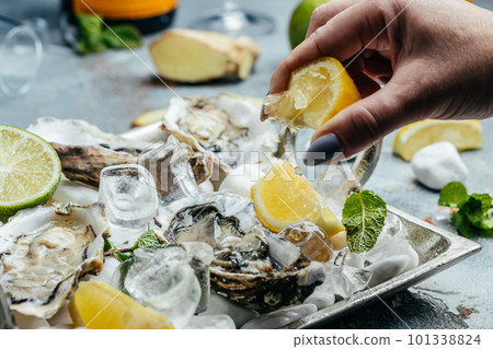 Fresh oysters on ice with lemon. Healthy food, gourmet food. Oyster dinner in restaurant Fresh oysters on ice with lemon. Healthy food, gourmet food. Oyster dinner in restaurant 101338824
