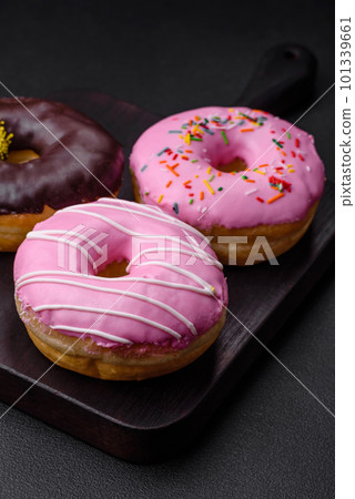 Delicious donut with cream filling and nuts on a dark concrete background 101339661