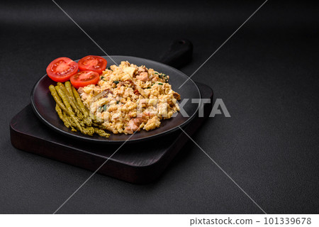 Delicious scramble with salmon, sun-dried tomatoes, spinach, spices and herbs 101339678