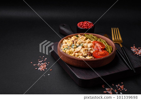 Delicious scramble with salmon, sun-dried tomatoes, spinach, spices and herbs 101339698