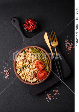 Delicious scramble with salmon, sun-dried tomatoes, spinach, spices and herbs 101339699