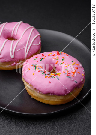 Delicious donut with cream filling and nuts on a dark concrete background Delicious donut with cream filling and nuts on a dark concrete background 101339718