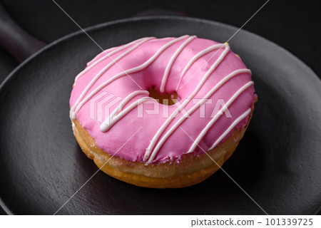 Delicious donut with cream filling and nuts on a dark concrete background Delicious donut with cream filling and nuts on a dark concrete background 101339725