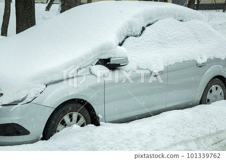 gray car covered with a snowdrift blocked in the parking lot, snowy spring morning cataclysm. gray car covered with a snowdrift blocked in the parking lot, snowy spring morning cataclysm. 101339762