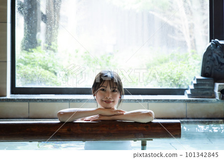 A young woman relaxing in a hot spring A young woman relaxing in a hot spring 101342845