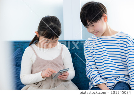 A child looking at a smartphone in the living room　 101345084