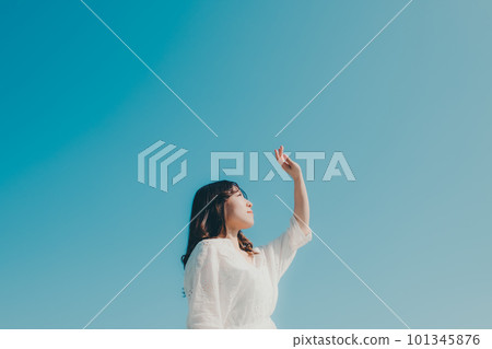 一個女人在藍天背景下握著她的手 101345876