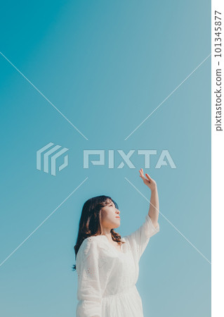 一個女人在藍天背景下握著她的手 一個女人在藍天背景下握著她的手 101345877