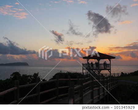 People looking at the sunset over the sea from the Unarizaki Park observation deck on Iriomote Island 101345929