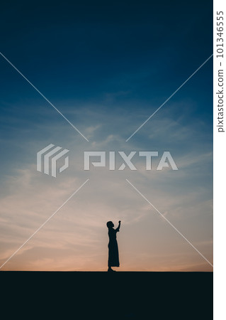 站在夕陽下的剪影女人 101346555