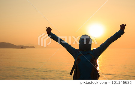 Cheering woman open arms at sunrise seaside beach Cheering woman open arms at sunrise seaside beach 101346625