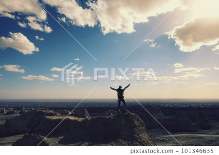 Successful female backpacker feel free on desert hill top 101346635