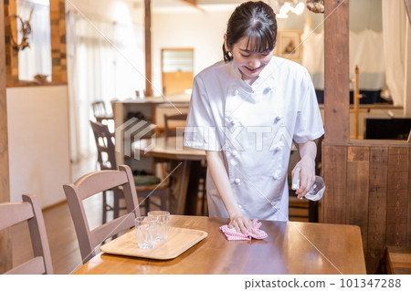 一名身穿廚師服的女廚房工作人員在咖啡館/餐廳進行收尾、清潔和整理工作 一名身穿廚師服的女廚房工作人員在咖啡館/餐廳進行收尾、清潔和整理工作 101347288