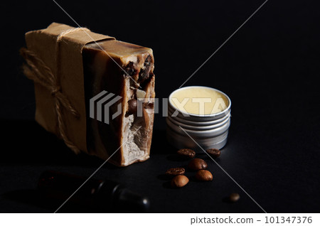 A bar with cold-pressed organic homemade soap with coffee beans and jar with wax, isolated black background. Natural ecological cosmetic products concept. Home spa, hygiene, skin and body care concept 101347376