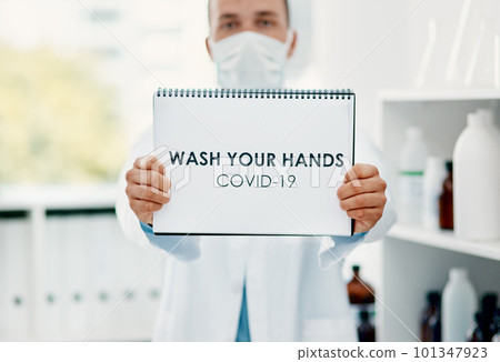 You know what you need to do. a scientist holding a sign with wash your hands on it in a laboratory. You know what you need to do. a scientist holding a sign with wash your hands on it in a laboratory. 101347923