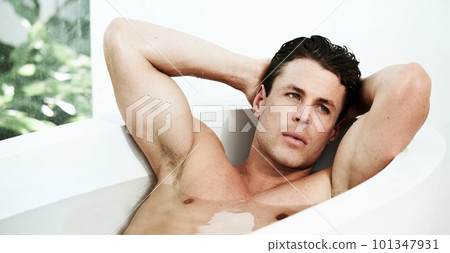 Soothing his muscles after a hard days work. a sexy male lying in the bathtub looking thoughtful. 101347931