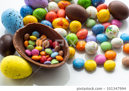 Colorful and chocolate easter eggs with sweet dragee on white background 101347994