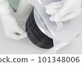 Gloved Hand Holding a Silicon Wafer in plastic holder box used in electronics for the fabrication of integrated circuits. Silicon wafer inspection. 101348006