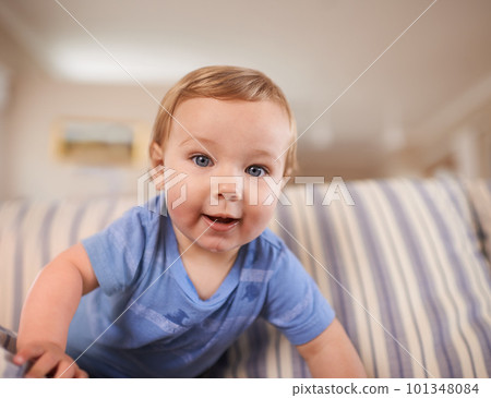 The cutest smile. an adorable little infant sitting on a sofa. The cutest smile. an adorable little infant sitting on a sofa. 101348084