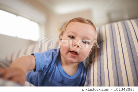 The cutest smile. an adorable little infant sitting on a sofa. The cutest smile. an adorable little infant sitting on a sofa. 101348085