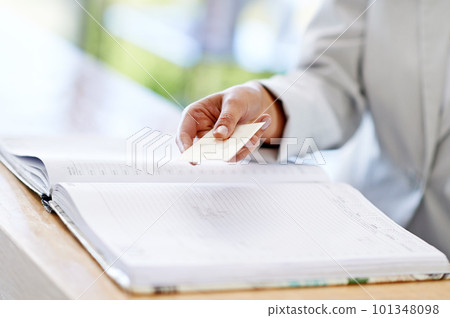 Ready to pay. a woman holding a business card at a reception desk. Ready to pay. a woman holding a business card at a reception desk. 101348098