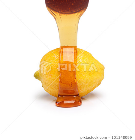 The feel-good combination. Studio shot of honey being poured on top of a lemon against a white background. The feel-good combination. Studio shot of honey being poured on top of a lemon against a white background. 101348099