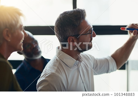 Serious, mature and expert business man doing presentation, planning and talking in a meeting in a boardroom. Manager doing training workshop, teaching and coaching new employees during conference 101348883