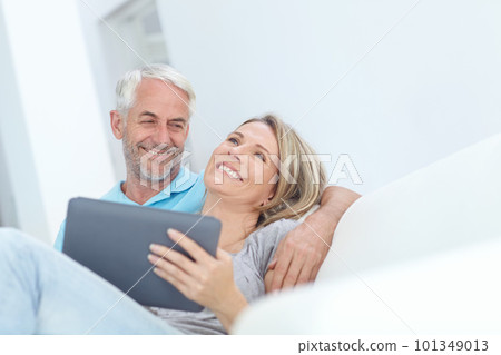 Senior, tablet and couple on a house couch on technology laughing and watching a movie on tech, Home, sofa and mature people in love with care smile about internet meme or social media scroll Senior, tablet and couple on a house couch on technology laughing and watching a movie on tech, Home, sofa and mature people in love with care smile about internet meme or social media scroll 101349013