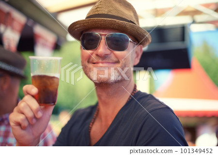 Heres to a good time. a man cheering with a plastic cup. Heres to a good time. a man cheering with a plastic cup. 101349452