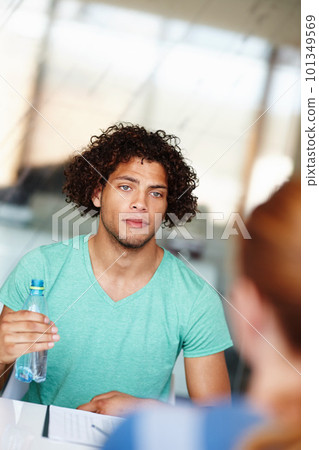 Hes intrigued by this new business. Young colleagues having a meeting in the office. Hes intrigued by this new business. Young colleagues having a meeting in the office. 101349569