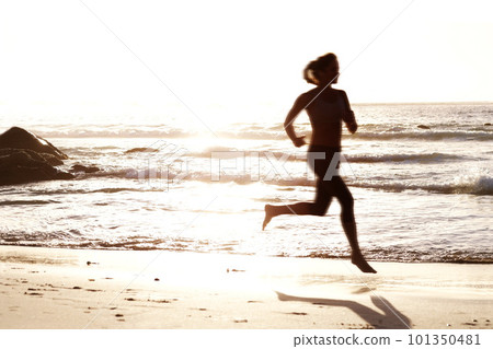 Young female running on beach during sunset. Portrait of a young female running on the sea shore at sunset. Young female running on beach during sunset. Portrait of a young female running on the sea shore at sunset. 101350481
