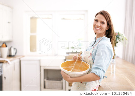 Perfecting her baking skills. A mature woman smiling as she bakes in the kitchen. 101350494