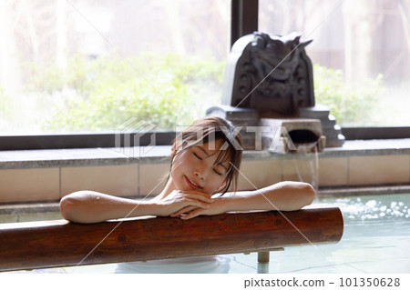 A young woman relaxing in a hot spring A young woman relaxing in a hot spring 101350628