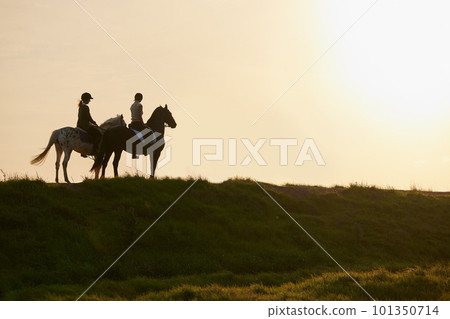 A horse is the projection of peoples dreams. Shot of two unrecognizable women riding their horses outside on a field. A horse is the projection of peoples dreams. Shot of two unrecognizable women riding their horses outside on a field. 101350714
