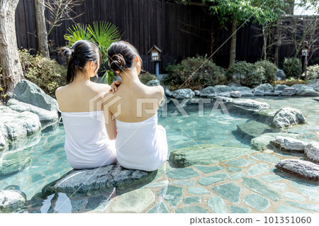 Two young women taking a leisurely open-air bath 101351060