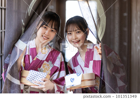 一位年輕女子走在旅館的連接走廊上，前往溫泉 101351349